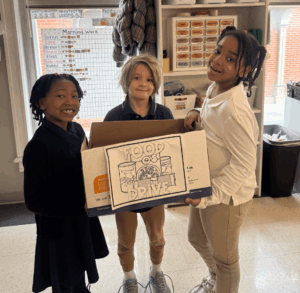 Students holding up their sign that they made for a food drive