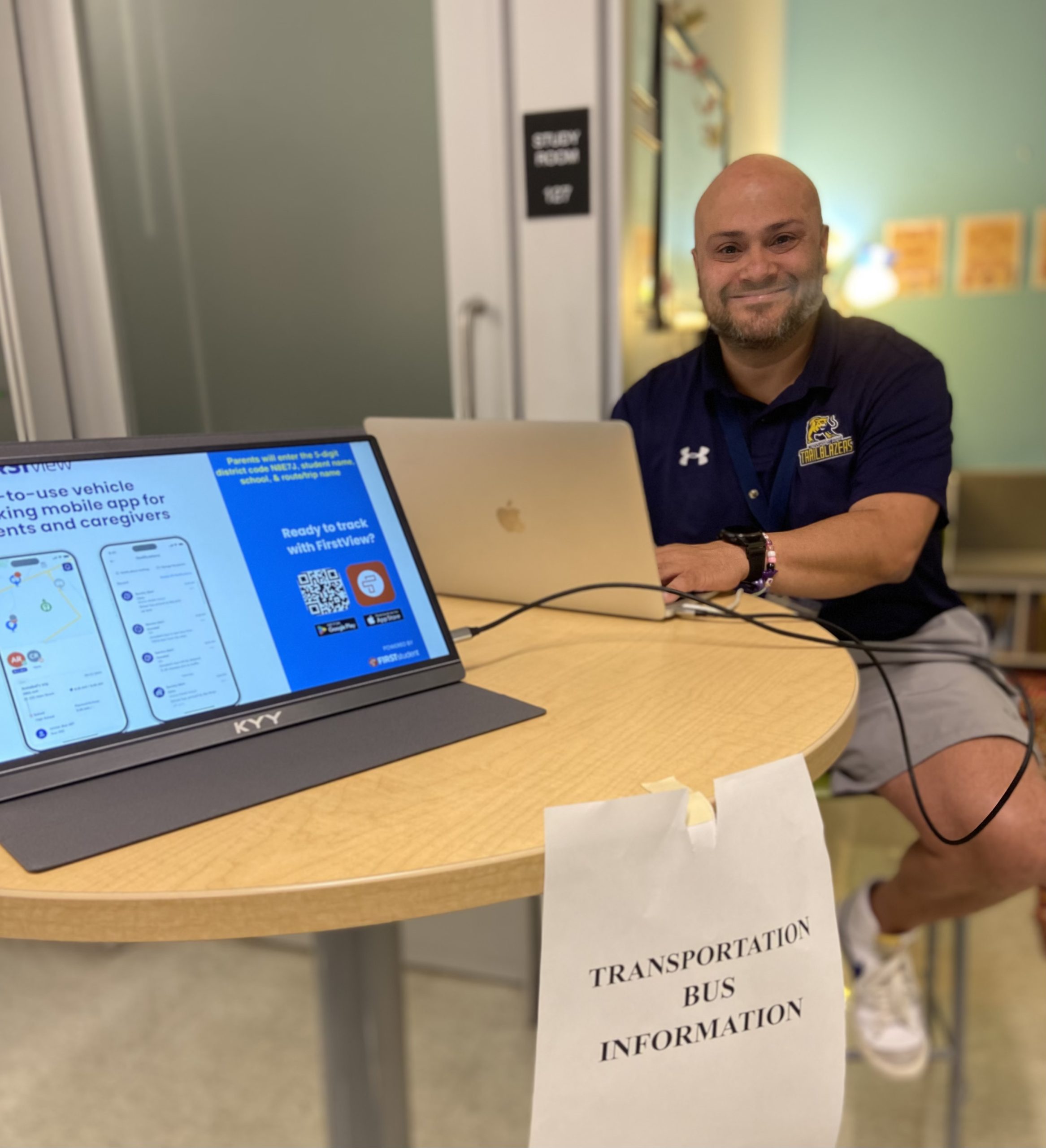 Teacher sitting at a table with laptops opened
